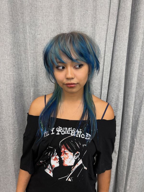 Electric blue fringe and face framing on a dark wolf cut