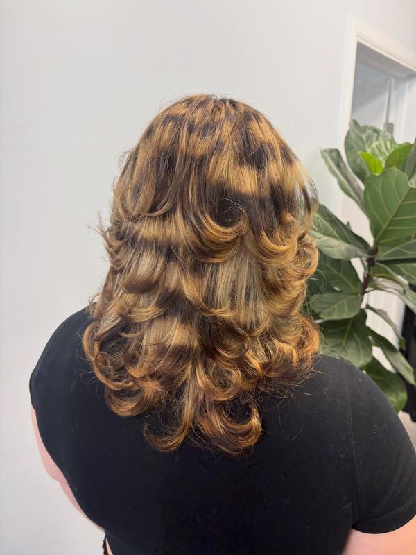 Dimensional bronde curls with warm highlights