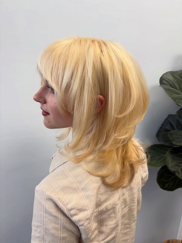 Platinum blonde shag with a soft fringe, side profile