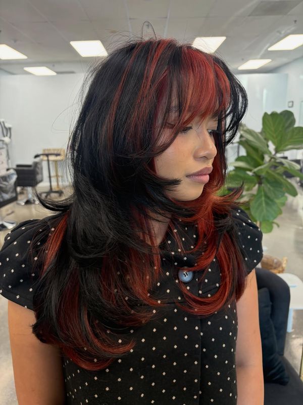 Black hair with a crimson red face frame and fringe