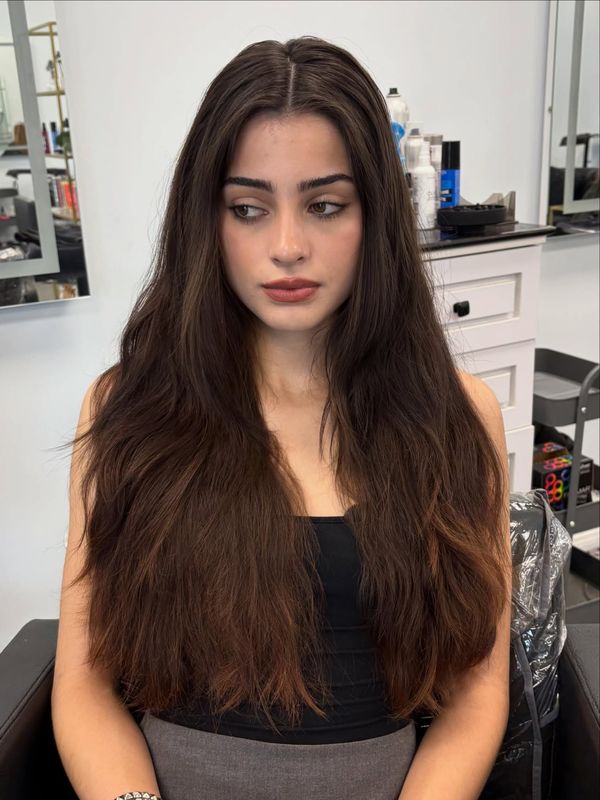 Waist length layered cut with a center part